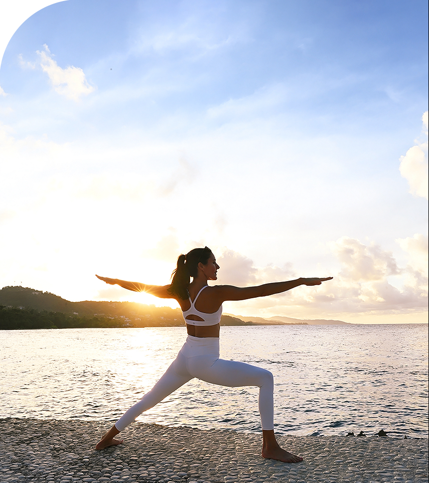 a woman in white yoga outfit on a beach