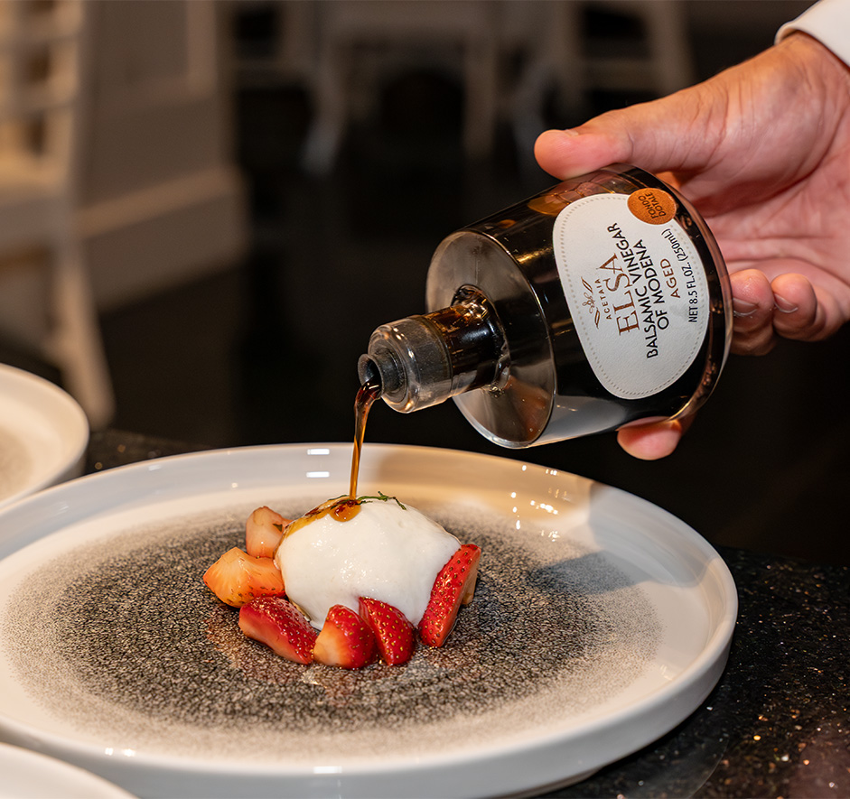 a person pouring a liquid onto a dessert