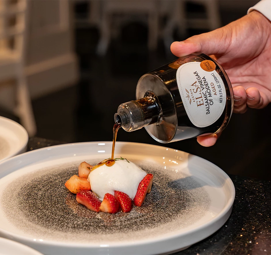 a person pouring a liquid onto a dessert