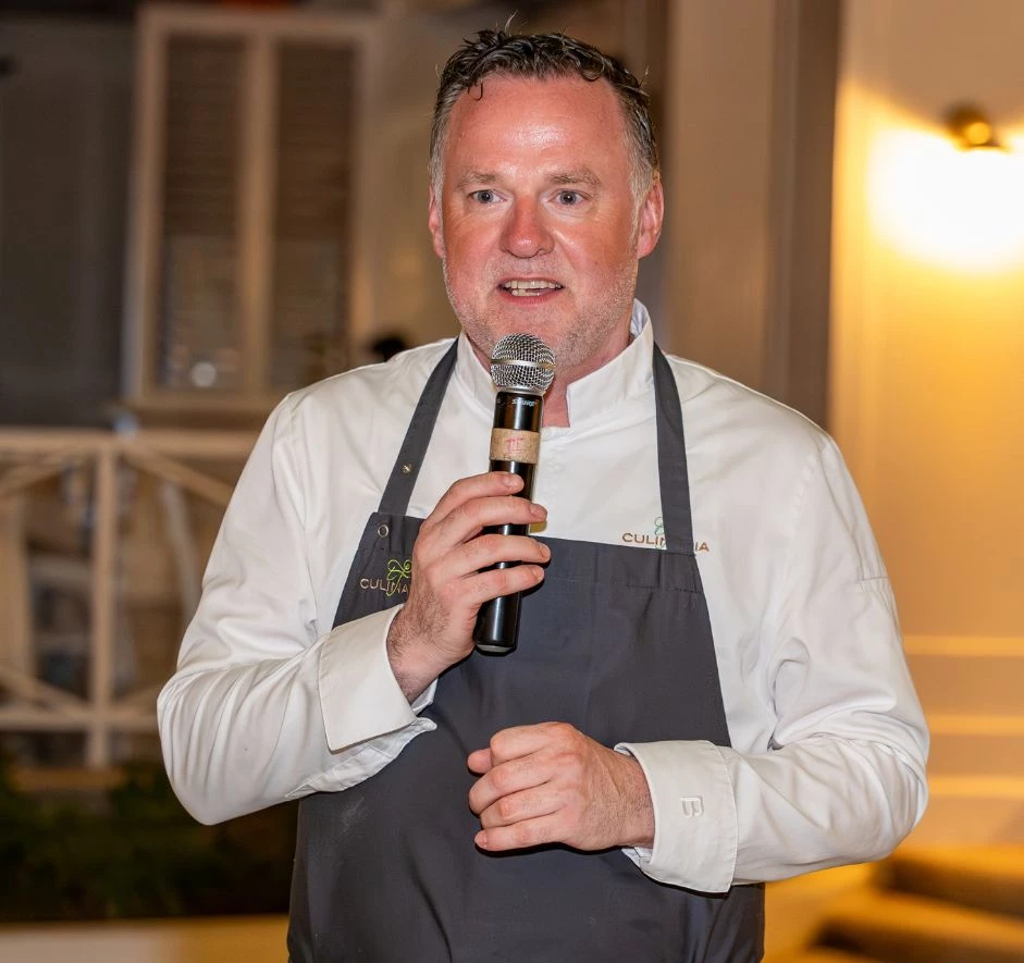 a man wearing an apron holding a microphone