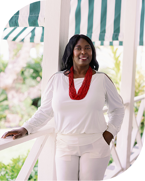 a woman wearing a red necklace and white pants