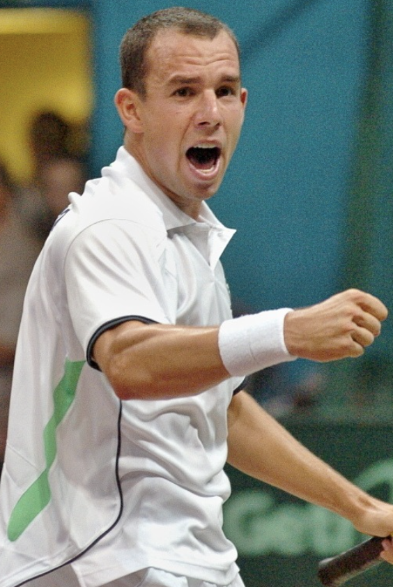 a male tennis player cheering with his mouth open