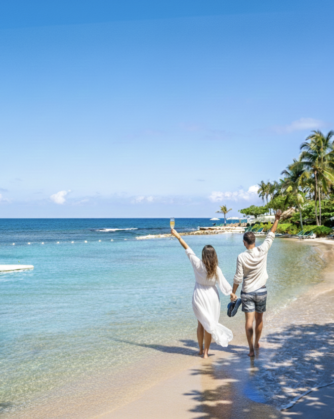 a man and woman holding hands on a beach