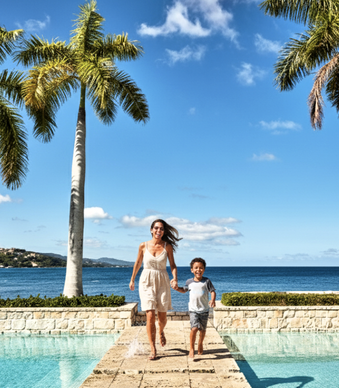 a woman and a boy running on a pool