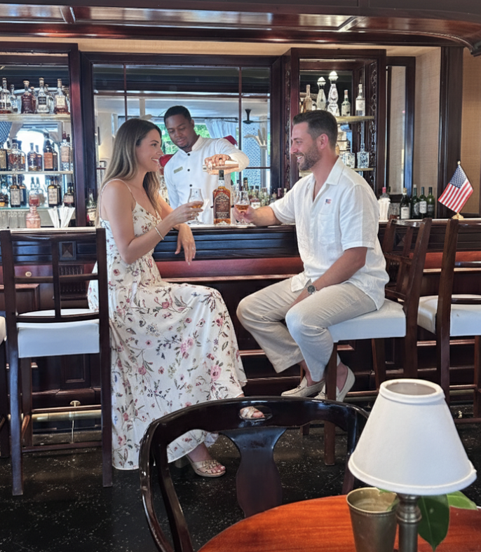 a man and woman sitting at a bar