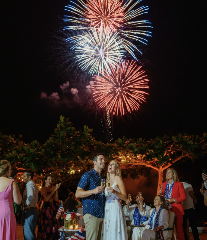 a man and woman standing in front of fireworks