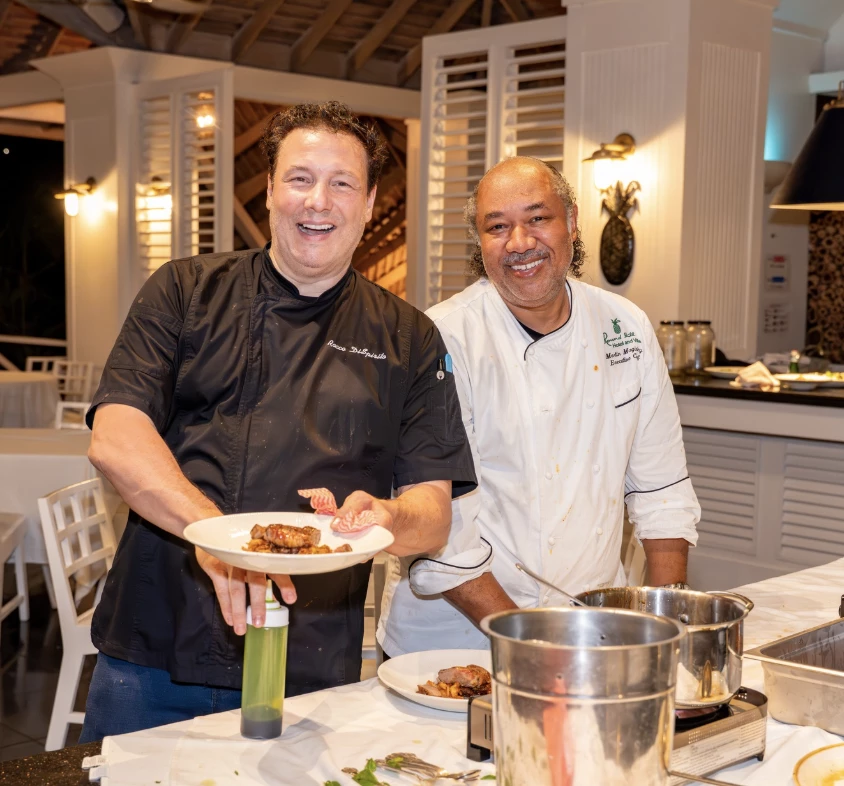 two men in chef's uniforms smiling at camera