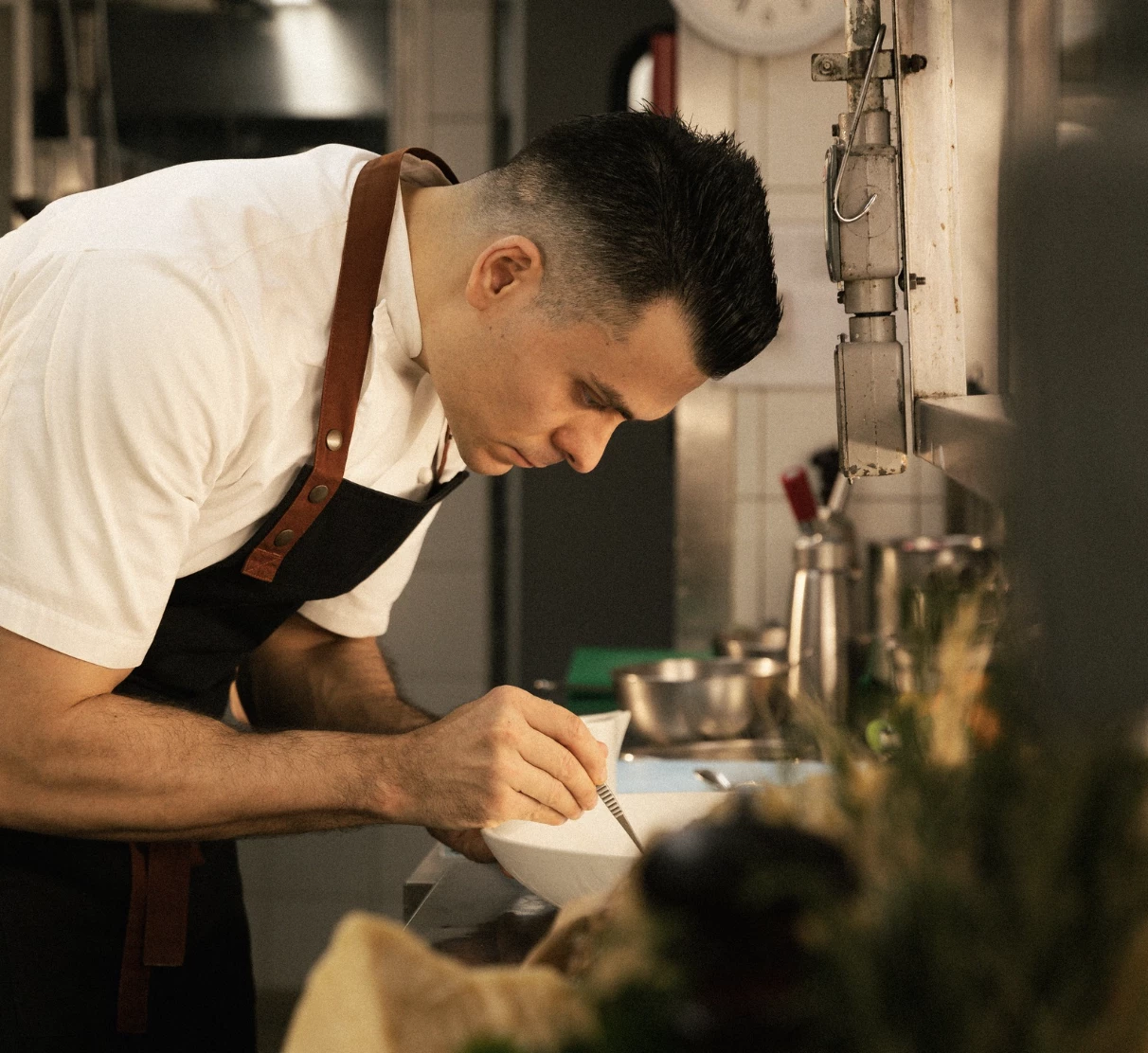 a man in a apron mixing food in a bowl