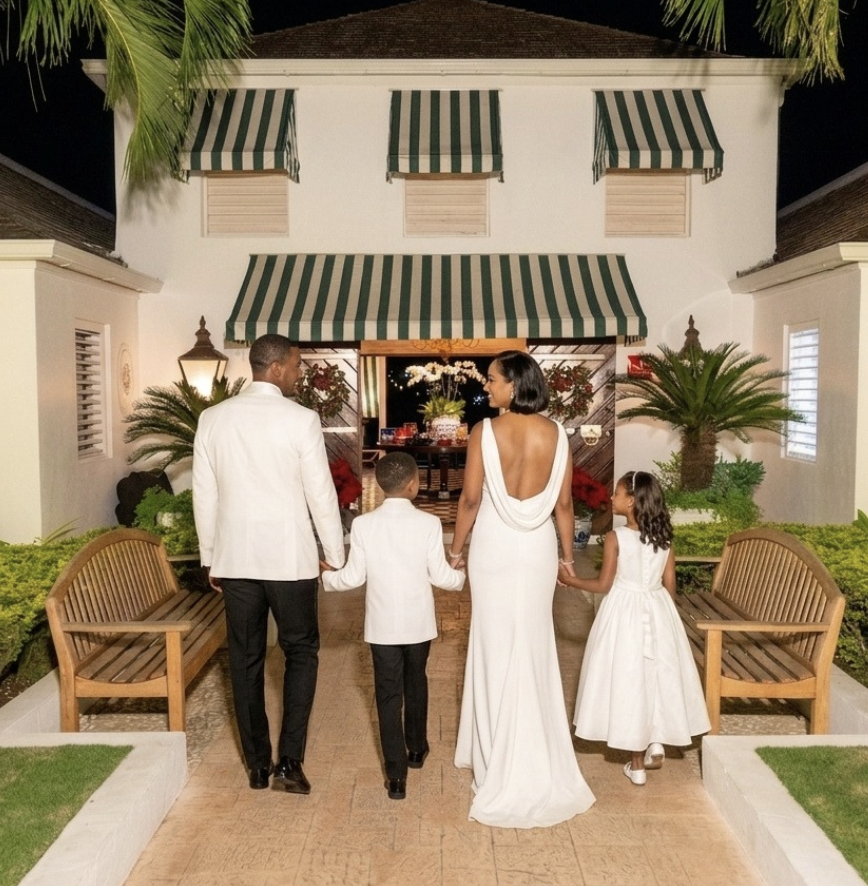 a man and woman in white dress walking down a walkway