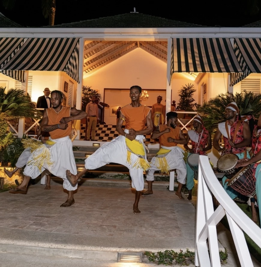 a group of men dancing in front of a house