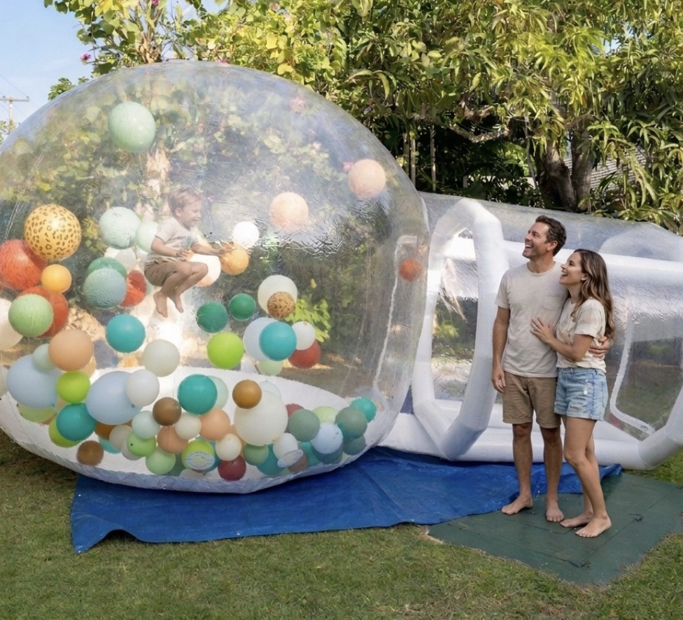 a man and woman standing next to a large inflatable ball