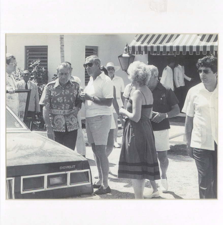 a group of people standing outside a car