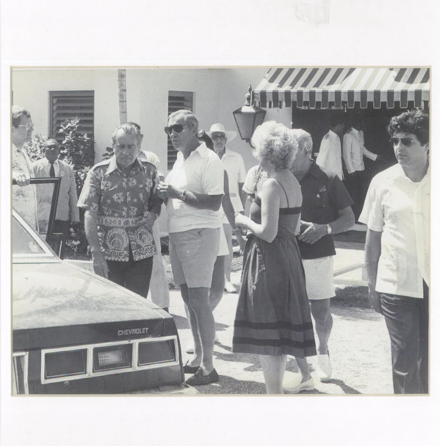a group of people standing outside a car
