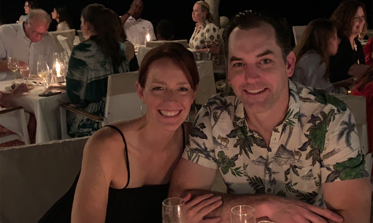 a man and woman sitting at a table with candles