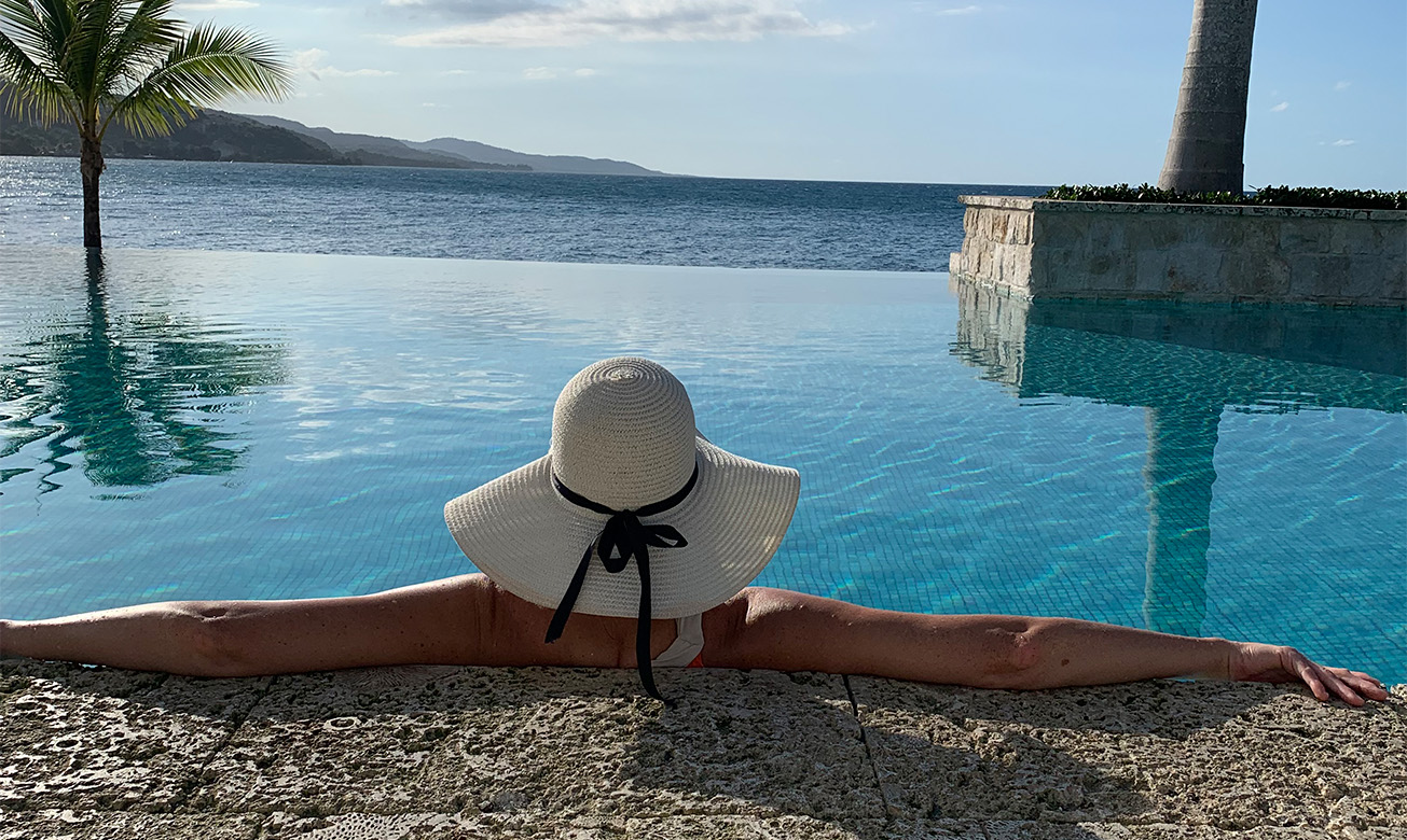 a woman in a hat by a pool