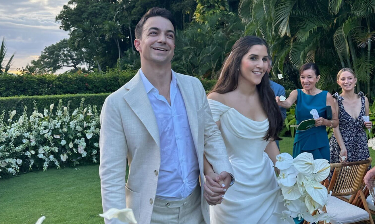 a man and woman in wedding attire holding hands and walking
