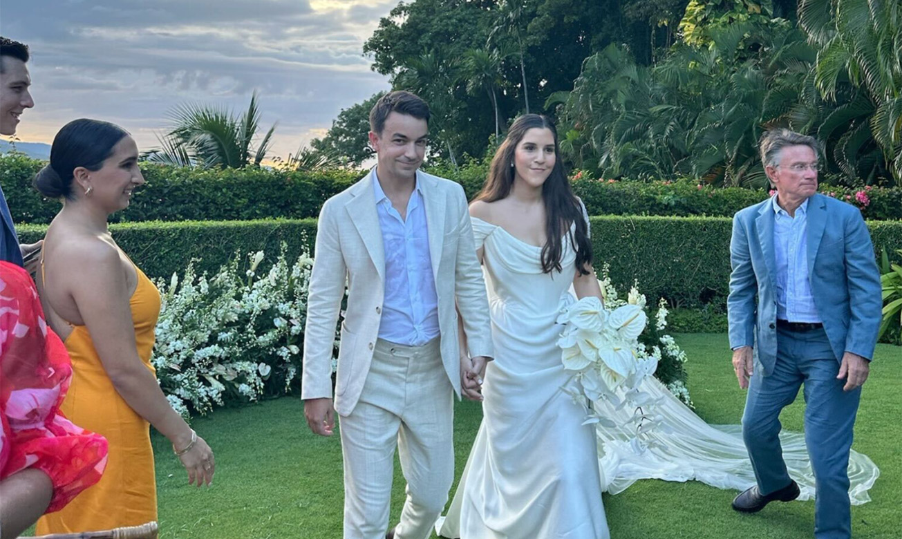 a man and woman in wedding attire walking on grass