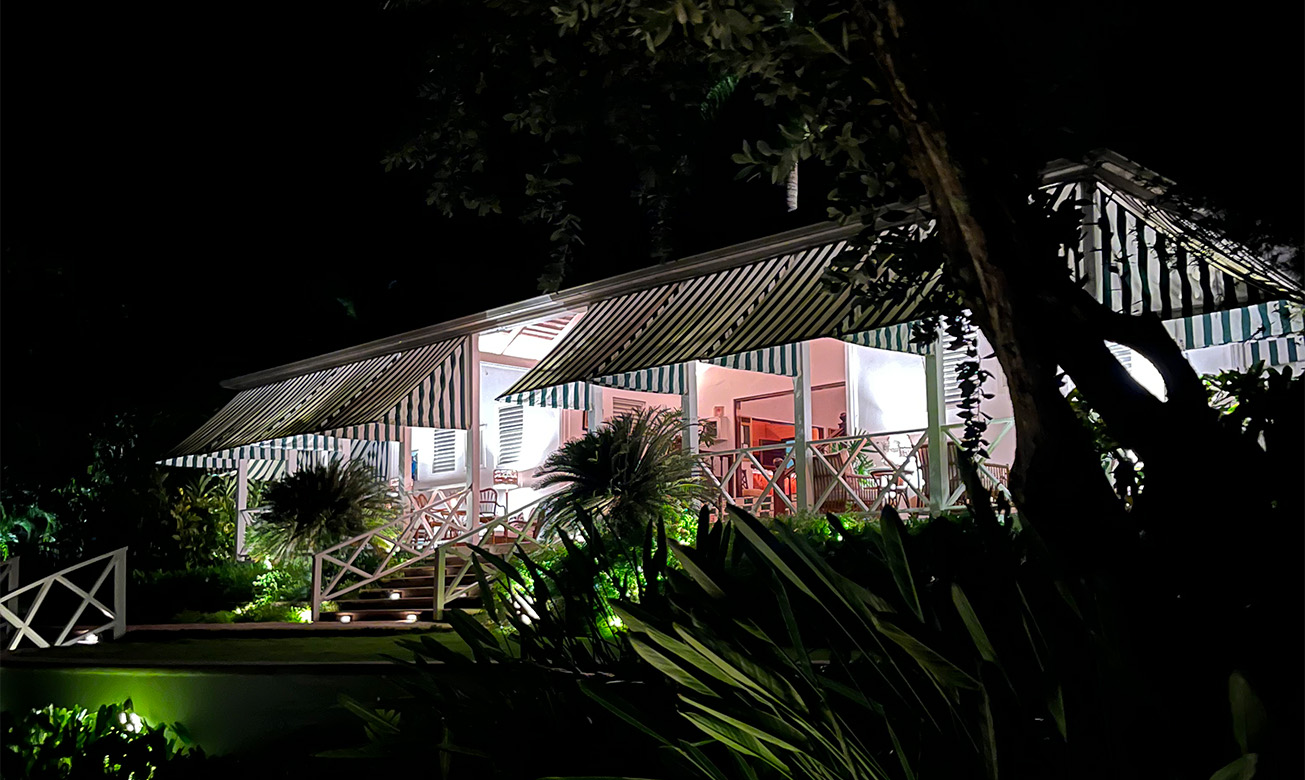 a building with a striped awning and a tree