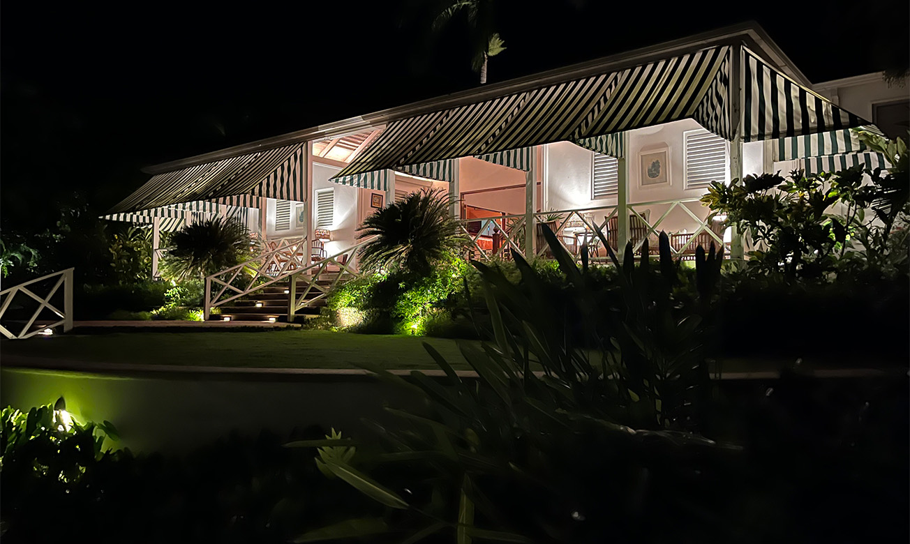 a building with a striped awning and palm trees