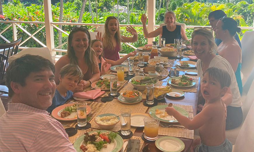 a group of people sitting at a table with food