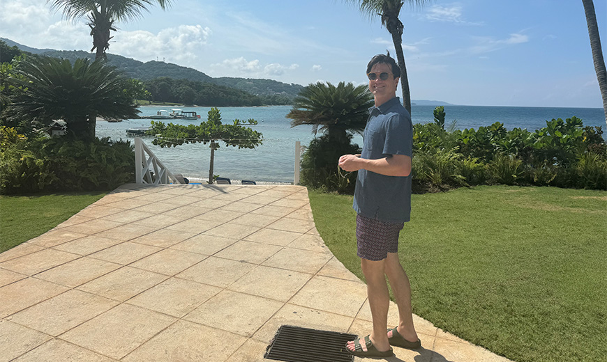 a man standing on a patio near a body of water