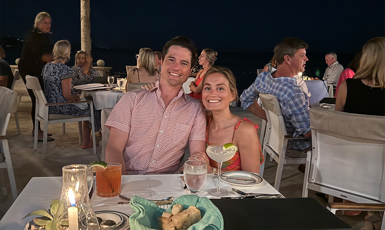 a man and woman sitting at a table with drinks