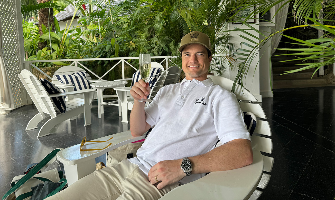 a man sitting in a chair holding a glass of champagne