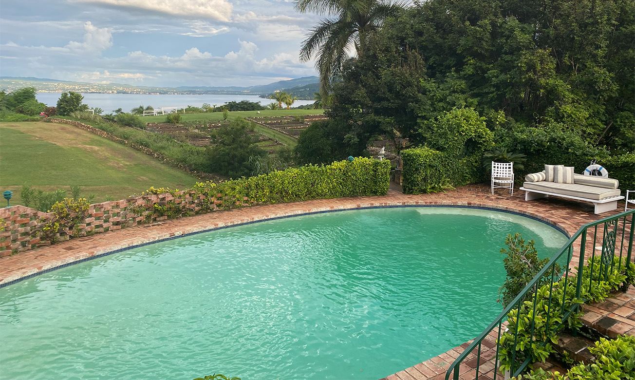 a pool with a view of a body of water and trees