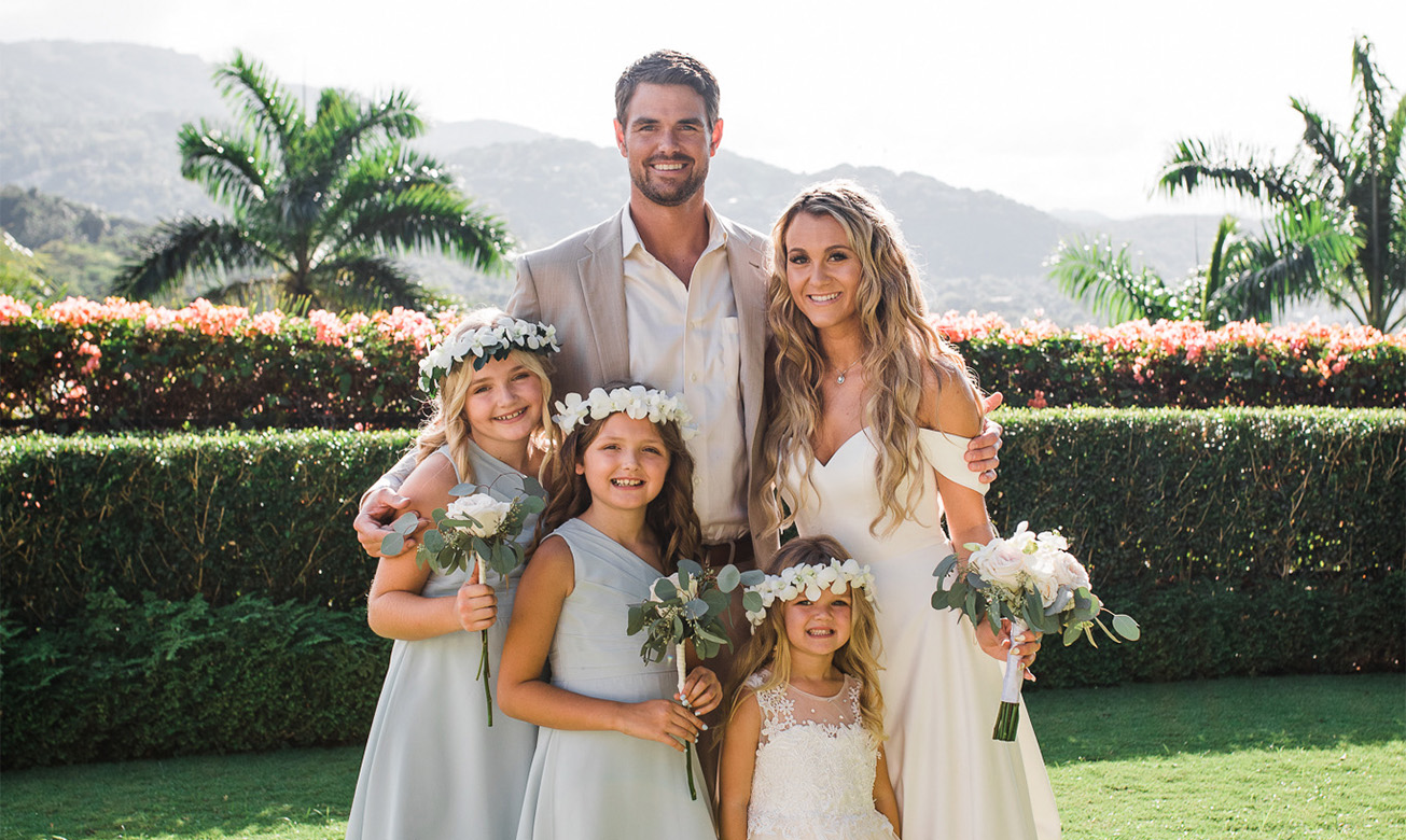 a man and woman with flowers and a group of girls