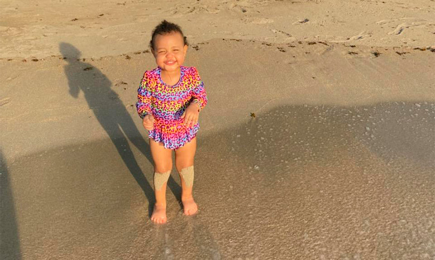 a baby standing on the beach