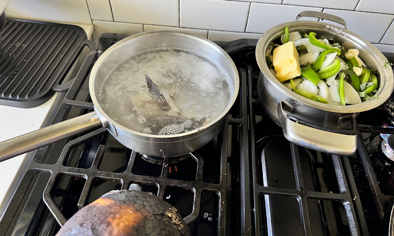 a pot of boiling water and pot of food on a stove