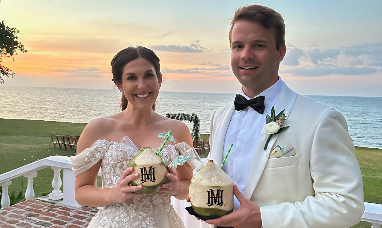 a man and woman holding coconuts