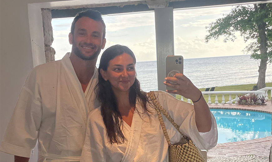 a man and woman in robes taking a selfie in a mirror