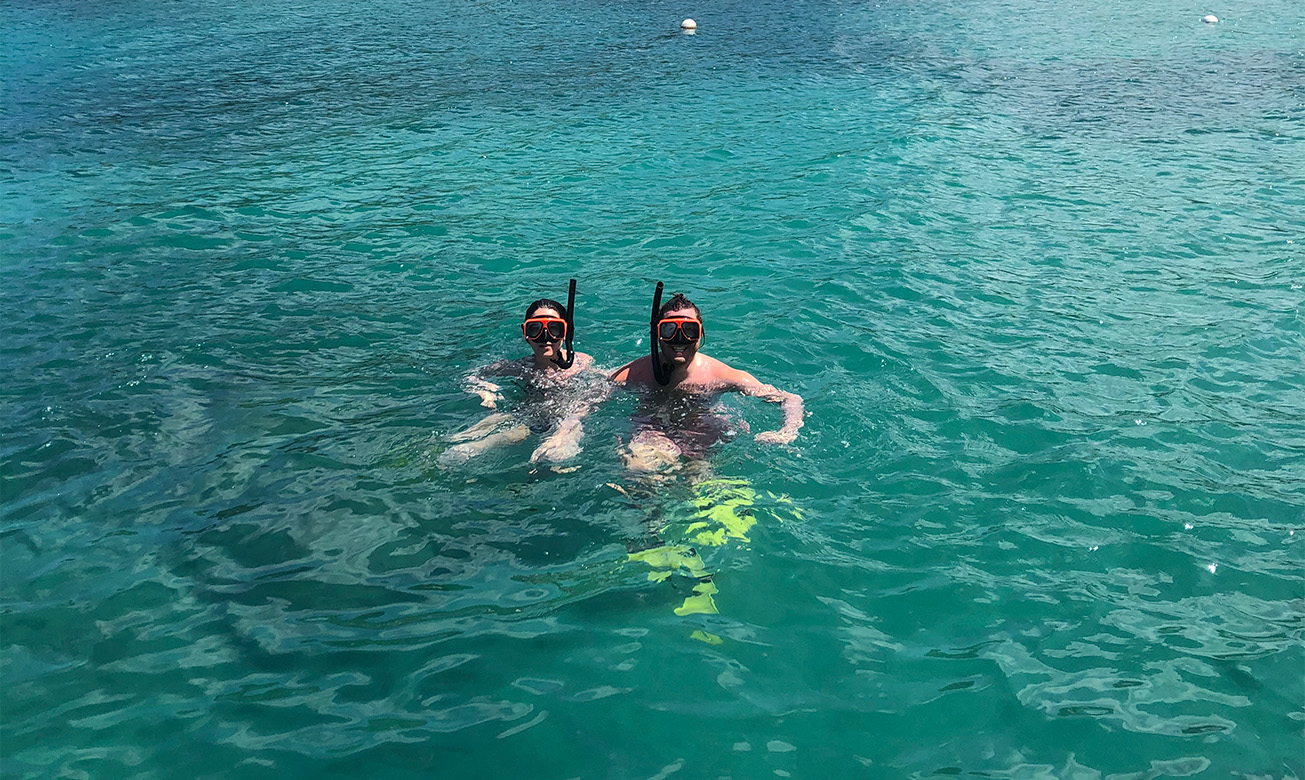 a couple of people in the water with snorkeling gear