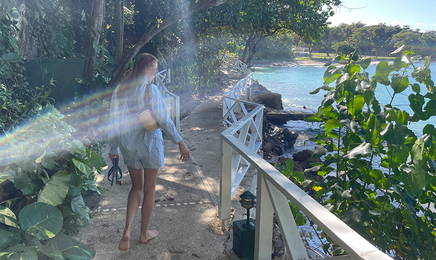 a woman walking on a path by a body of water