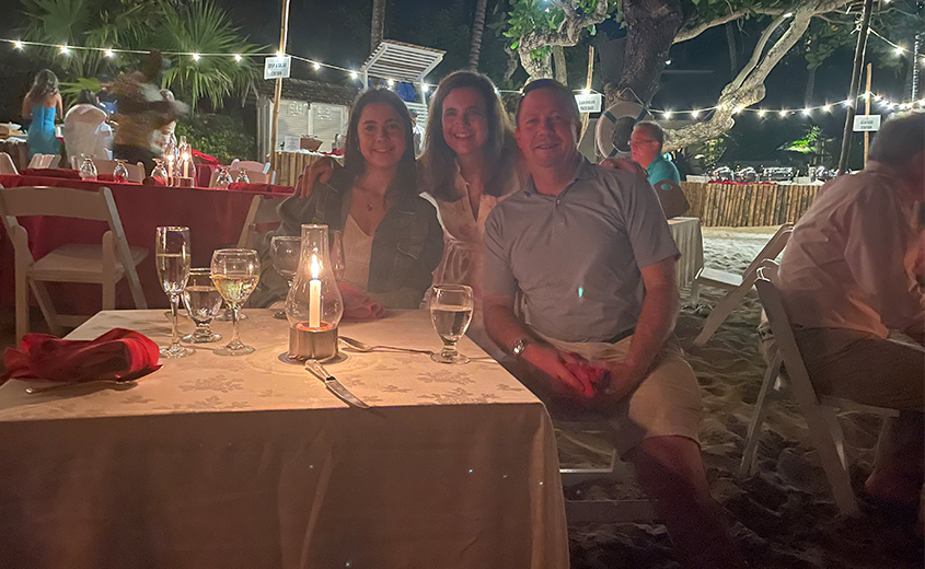 a group of people sitting at a table with wine glasses and candles