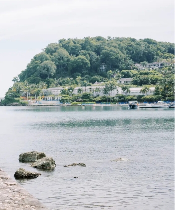 a body of water with a hill in the background