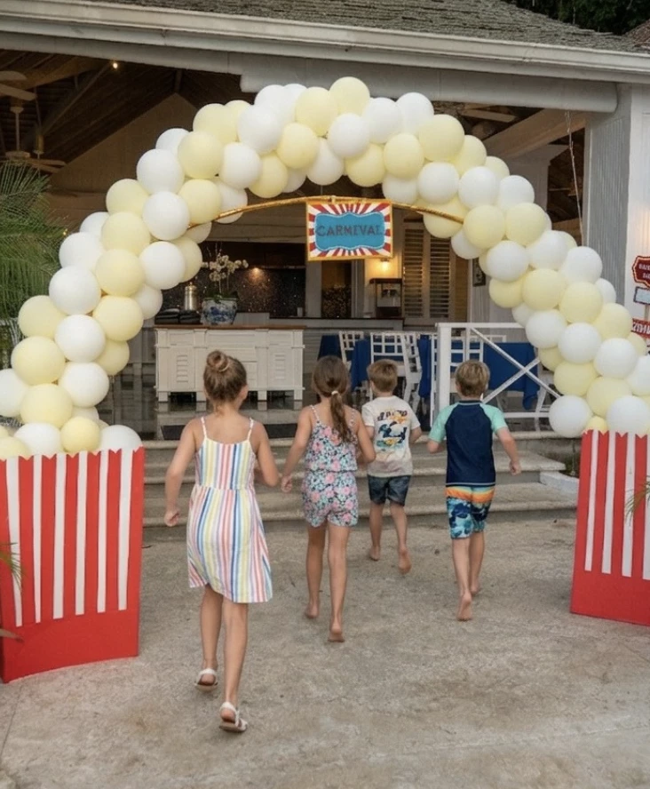 a group of kids running through a carnival entrance