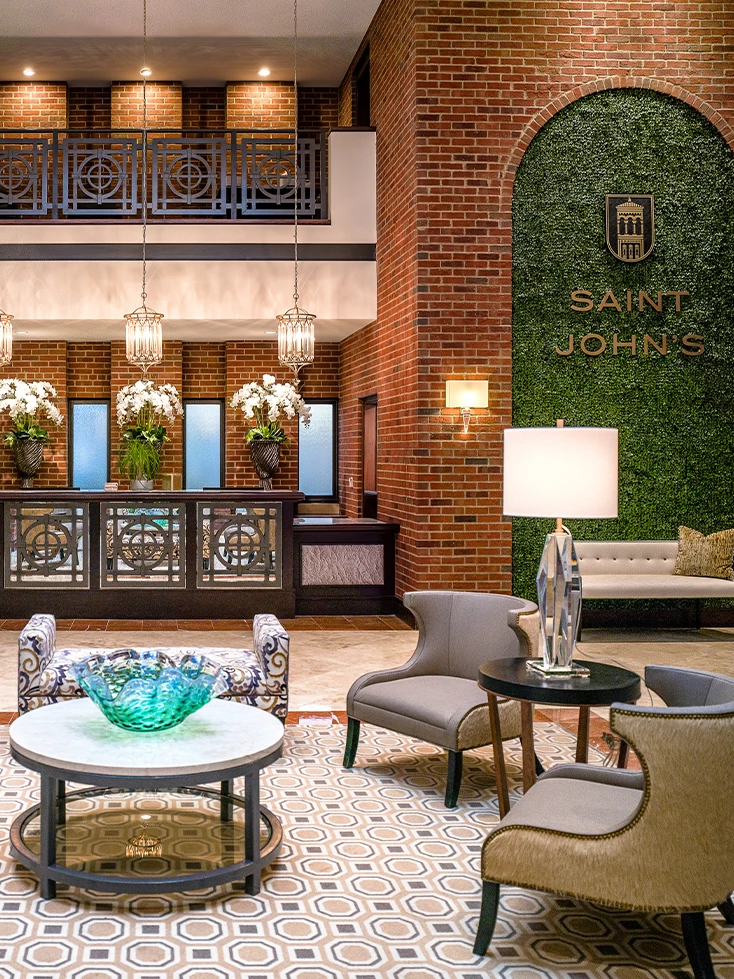 a lobby with a brick wall and a table and chairs