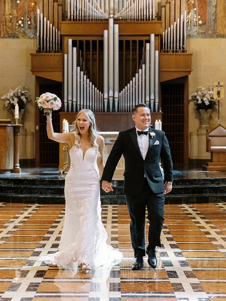 a bride and groom walking in a church