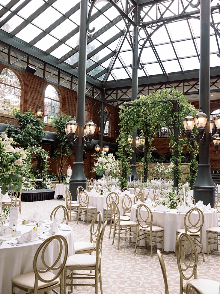 a room with tables and chairs and flowers