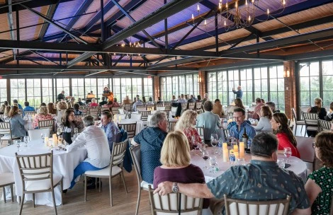 a group of people sitting at tables in a room with a large roof