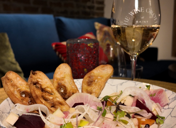 a bowl of food and a glass of wine