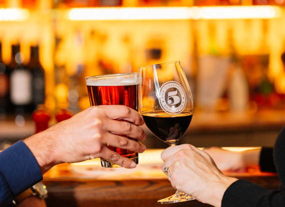 a couple of hands holding wine glasses