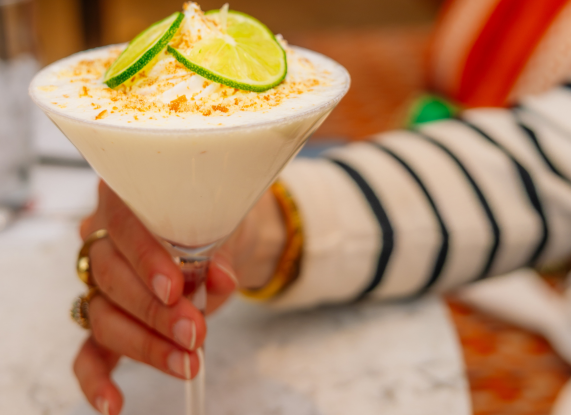 a hand holding a glass of food