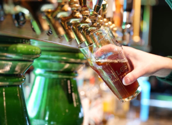 a hand holding a glass of beer