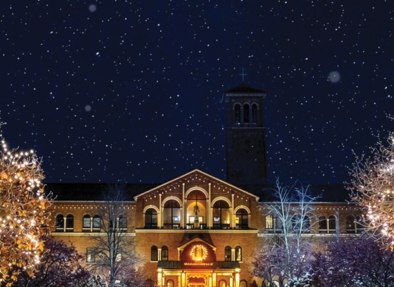 a building with lights and trees in front of it