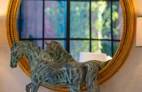 a statue of a horse in front of a mirror