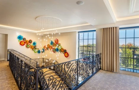a staircase with a metal railing and a chandelier