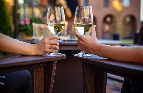 a pair of hands holding wine glasses